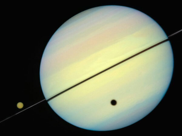 Saturn und Trabanten – Planetenringe und Monde im Detail Saturn mit seinen Ringen und zwei sichtbaren Trabanten im Weltraum